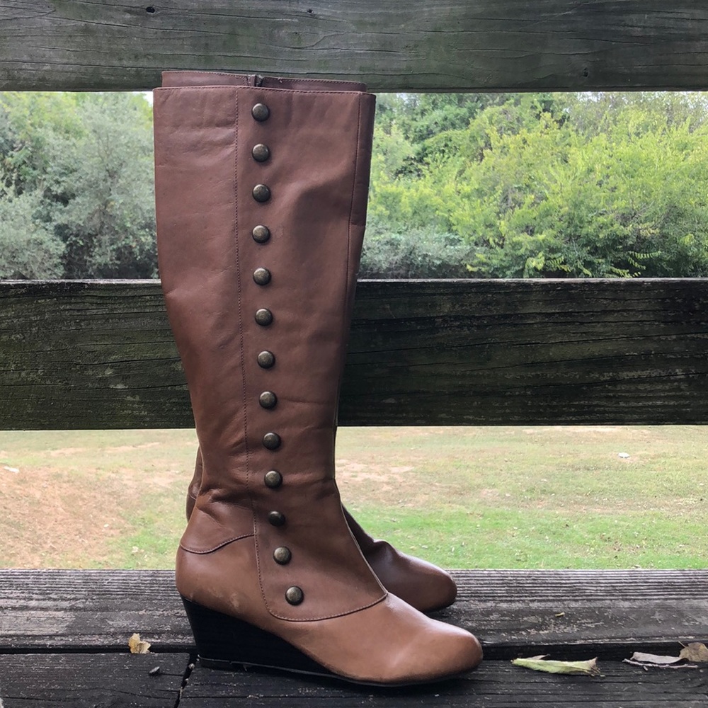 Tall brown boots with brass accents
